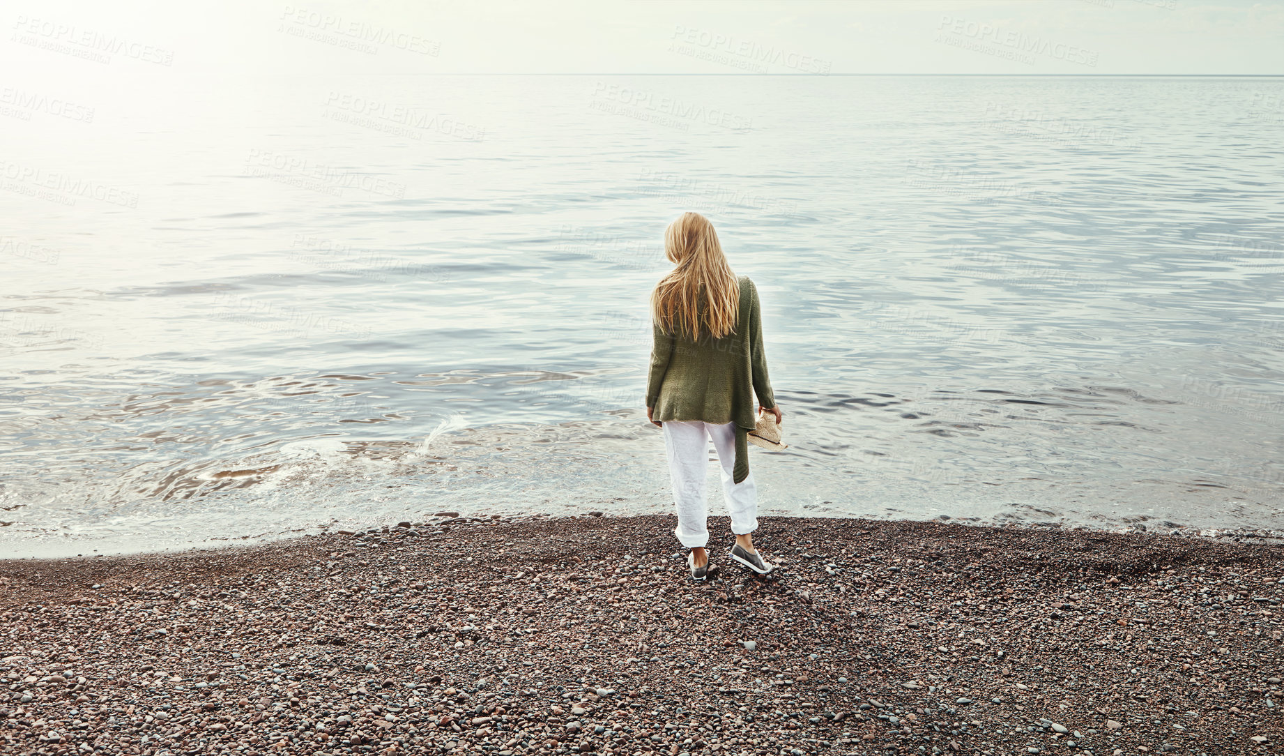 Buy stock photo Shot of a young woman spending a day at the lake