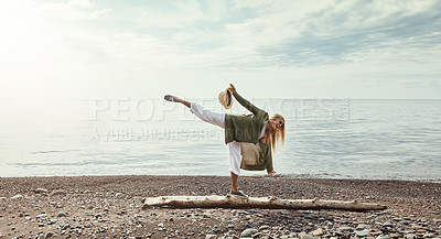 Buy stock photo Shot of a young woman walking along a log at a lake