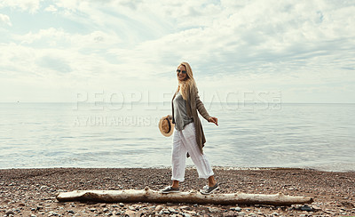 Buy stock photo Shot of a young woman walking along a log at a lake