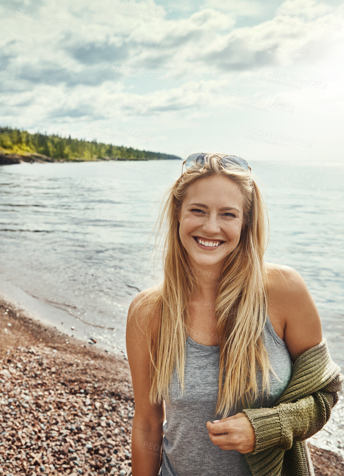 Buy stock photo Shot of a young woman spending a day at the lake