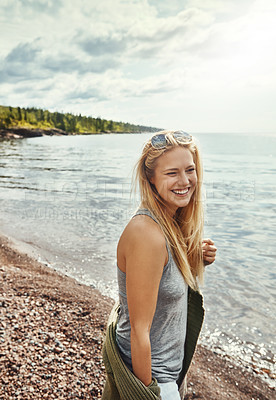 Buy stock photo Shot of a young woman spending a day at the lake