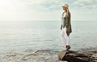 Buy stock photo Happy woman, thinking and beach with hat in nature sunshine on outdoor holiday, weekend or journey. Young female person on rock with smile for travel, vacation or freedom by ocean coast, water or sea