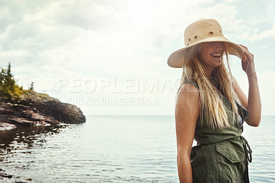 Buy stock photo Outdoor, happy and woman by beach for holiday, getaway or weekend trip in summer with travel. Hat, space and female person by ocean water for seaside vacation with relax, calm and peace on break.