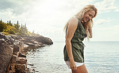 Buy stock photo Shot of an attractive young woman spending a day at the lake