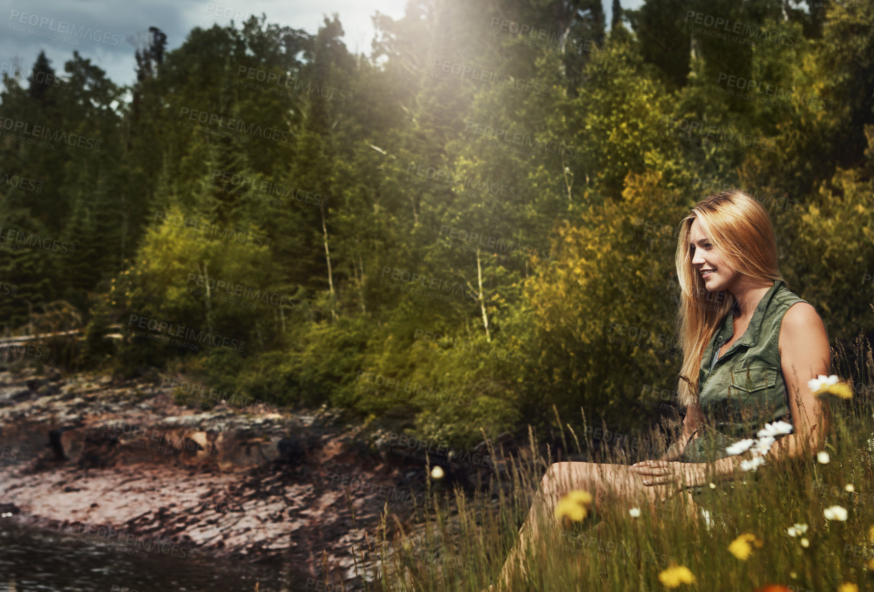 Buy stock photo Shot of an attractive young woman spending a day at the lake