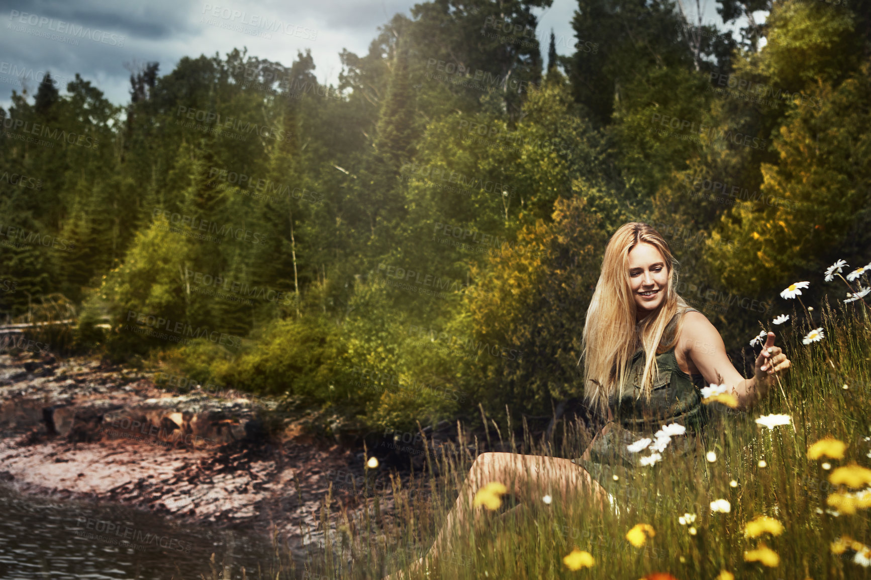 Buy stock photo Shot of an attractive young woman spending a day at the lake