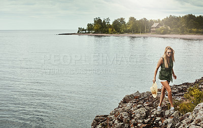 Buy stock photo Shot of an attractive young woman spending a day at the lake