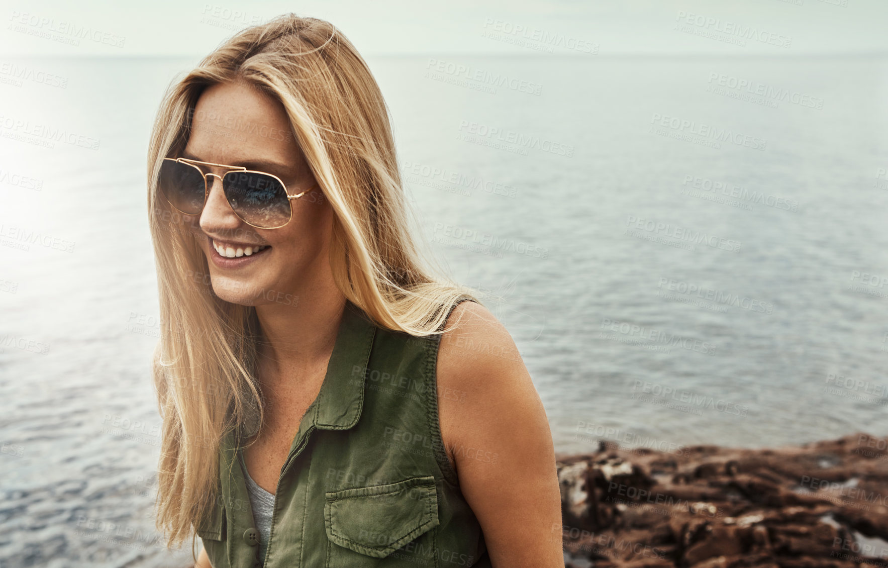 Buy stock photo Shot of an attractive young woman spending a day at the lake