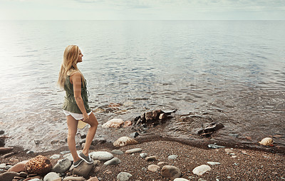 Buy stock photo Shot of an attractive young woman spending a day at the lake