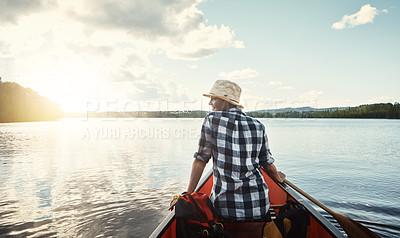 Buy stock photo Shot of an attractive young woman spending a day kayaking on the lake