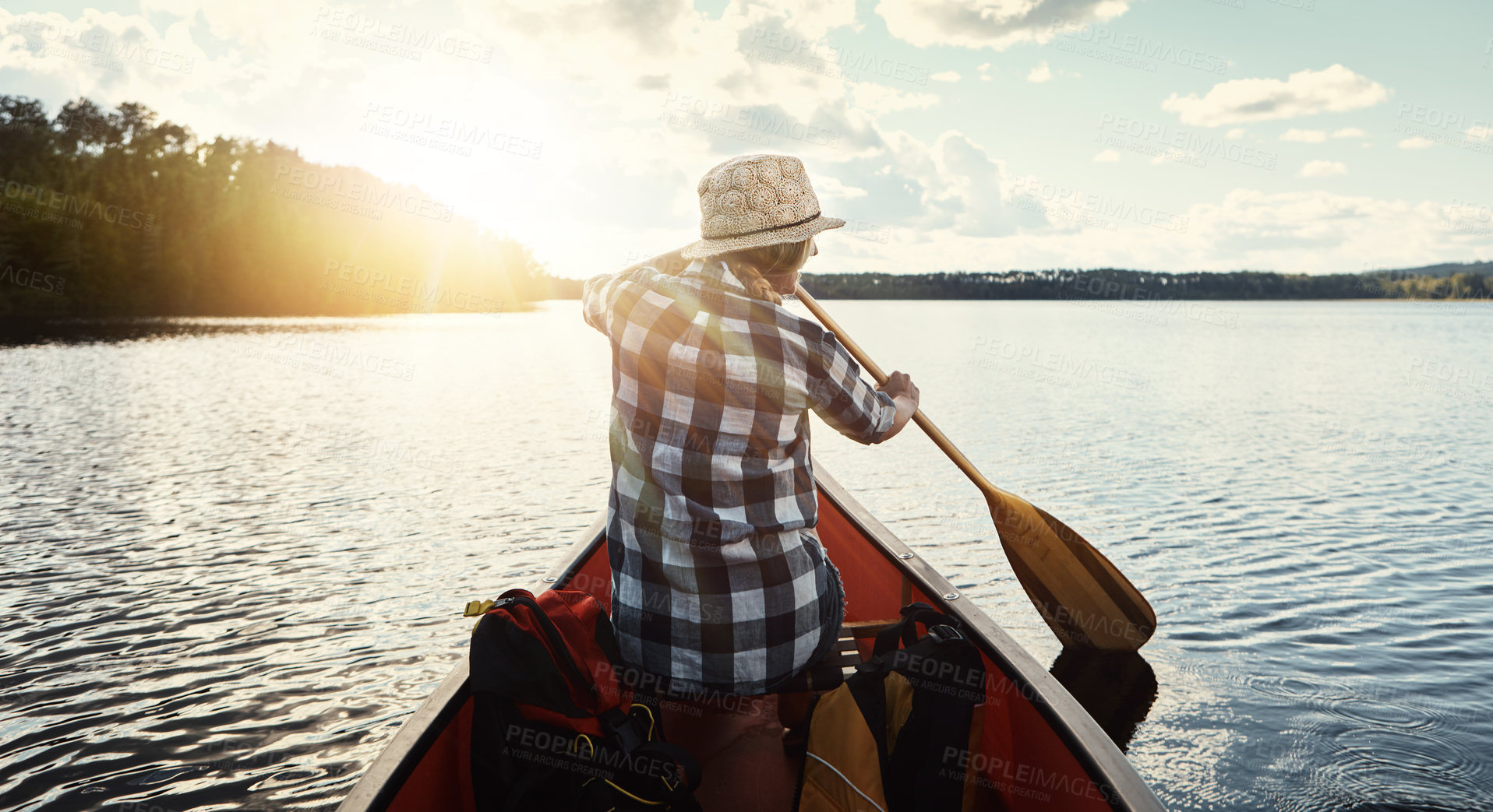 Buy stock photo Shot of an attractive young woman spending a day kayaking on the lake