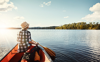 Buy stock photo Shot of an attractive young woman spending a day kayaking on the lake