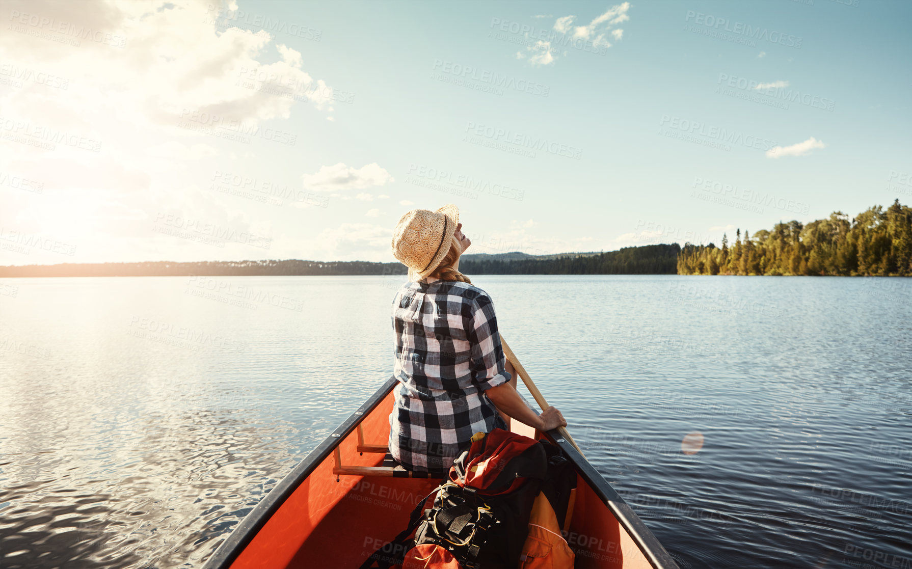 Buy stock photo Shot of an attractive young woman spending a day kayaking on the lake