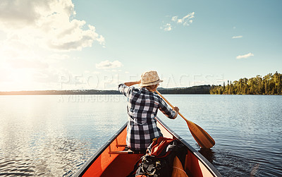 Buy stock photo Shot of an attractive young woman spending a day kayaking on the lake