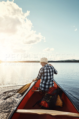 Buy stock photo Shot of an attractive young woman spending a day kayaking on the lake