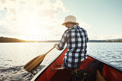 Buy stock photo Shot of an attractive young woman spending a day kayaking on the lake