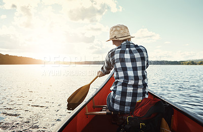 Buy stock photo Shot of an attractive young woman spending a day kayaking on the lake