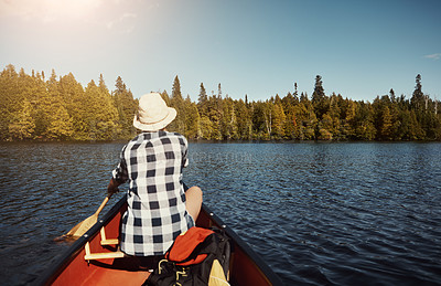 Buy stock photo Shot of an attractive young woman spending a day kayaking on the lake