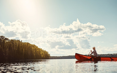 Buy stock photo Shot of an attractive young woman spending a day kayaking on the lake