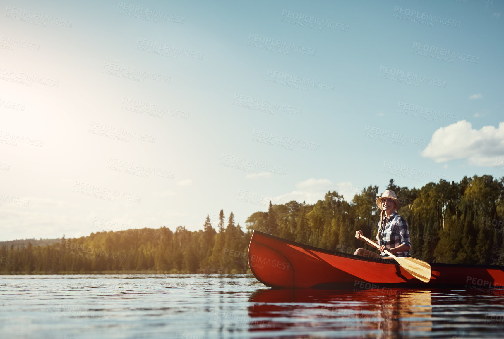 Buy stock photo Shot of an attractive young woman spending a day kayaking on the lake