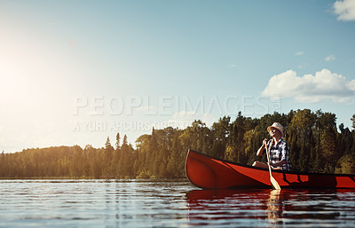 Buy stock photo Shot of an attractive young woman spending a day kayaking on the lake