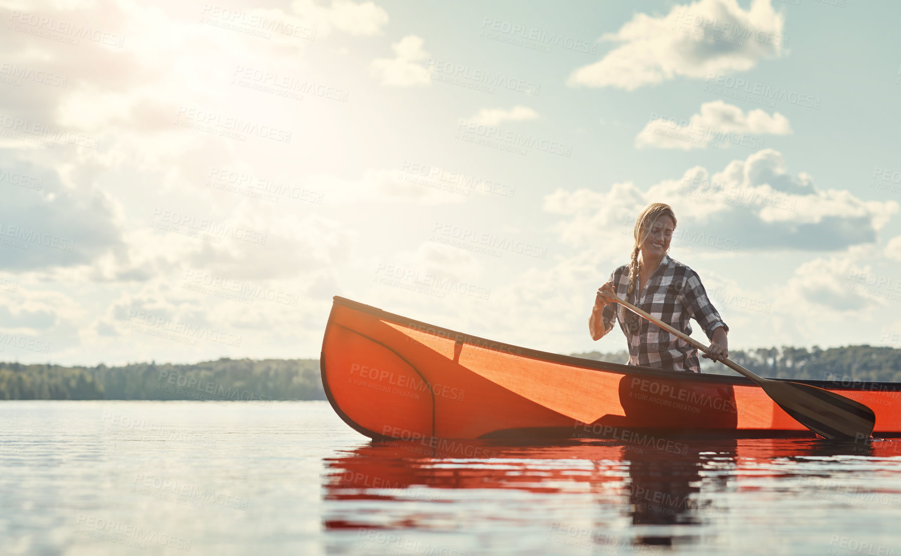 Buy stock photo Shot of an attractive young woman spending a day kayaking on the lake