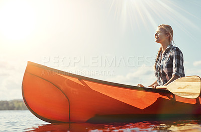 Buy stock photo Shot of an attractive young woman spending a day kayaking on the lake