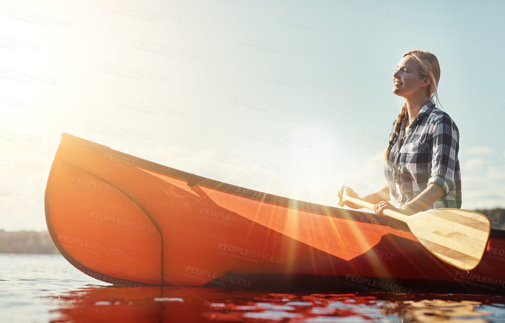 Buy stock photo Shot of an attractive young woman spending a day kayaking on the lake