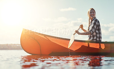 Buy stock photo Shot of an attractive young woman spending a day kayaking on the lake