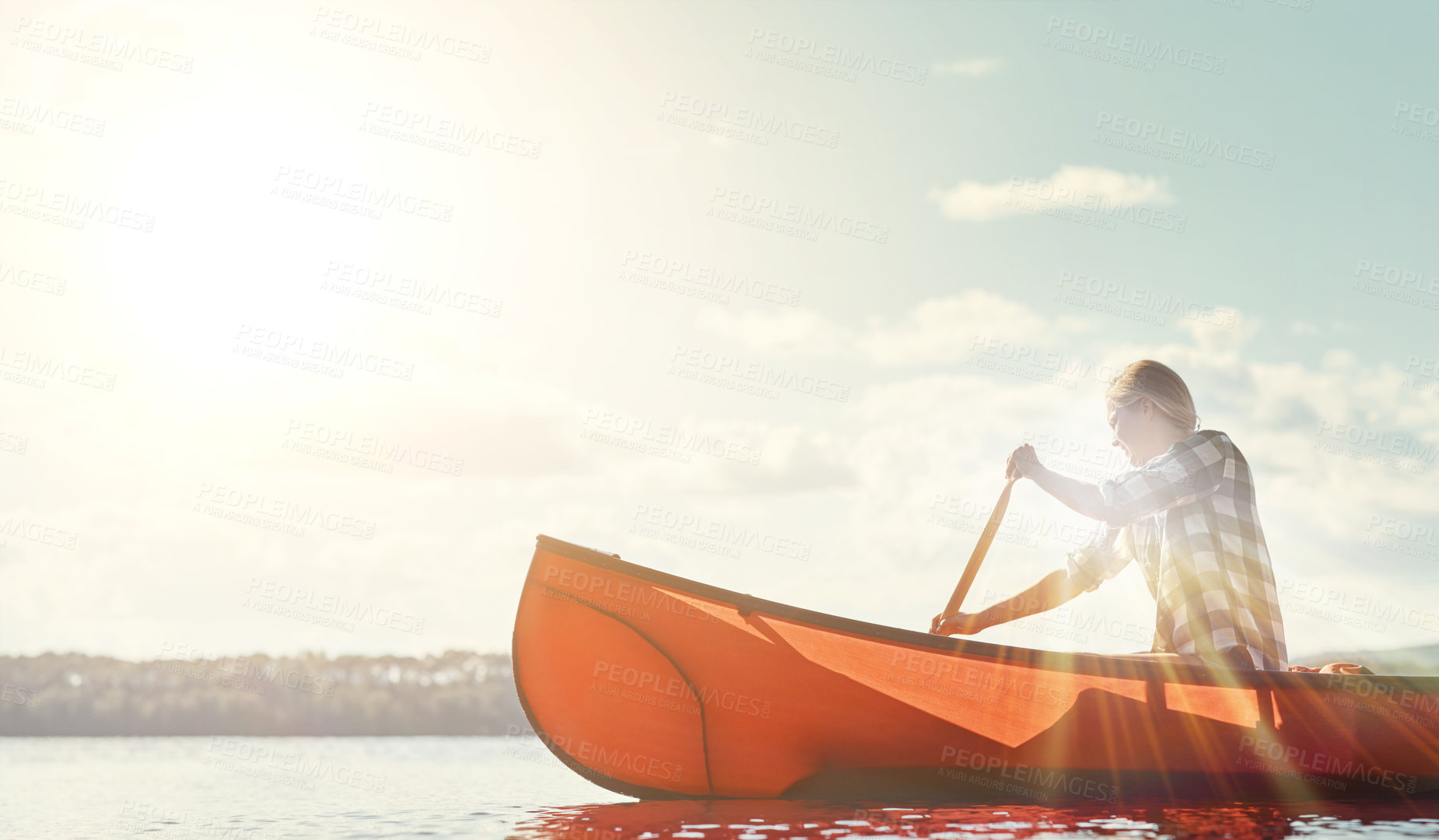 Buy stock photo Shot of an attractive young woman spending a day kayaking on the lake