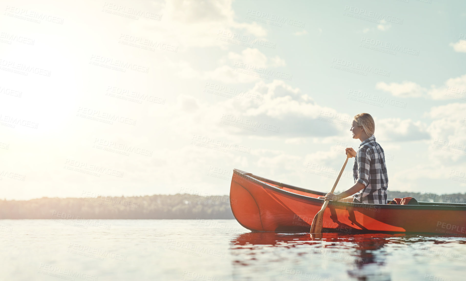 Buy stock photo Shot of an attractive young woman spending a day kayaking on the lake