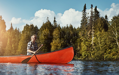 Buy stock photo Shot of an attractive young woman spending a day kayaking on the lake