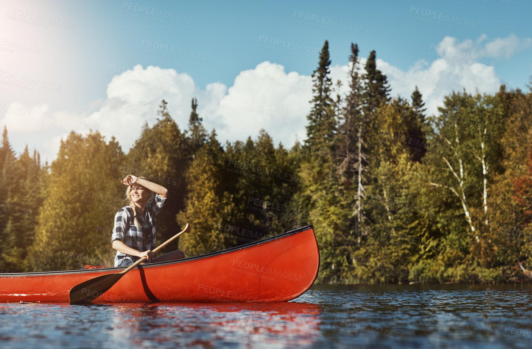 Buy stock photo Shot of an attractive young woman spending a day kayaking on the lake