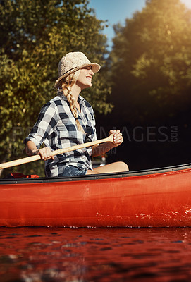 Buy stock photo Shot of an attractive young woman spending a day kayaking on the lake