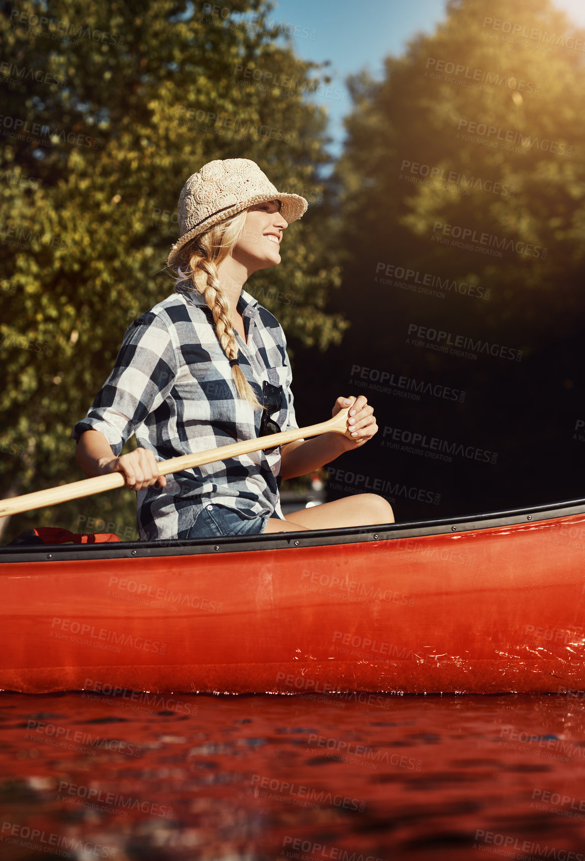 Buy stock photo Shot of an attractive young woman spending a day kayaking on the lake