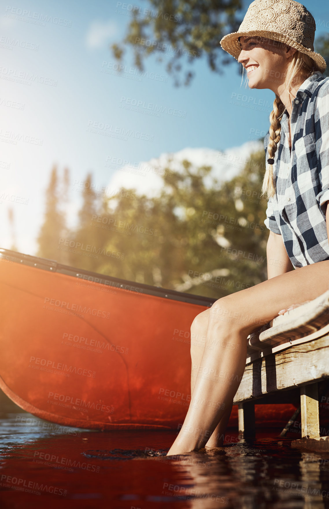 Buy stock photo Shot of an attractive young woman spending a day relaxing by the lake