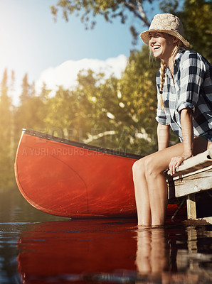 Buy stock photo Shot of an attractive young woman spending a day relaxing by the lake