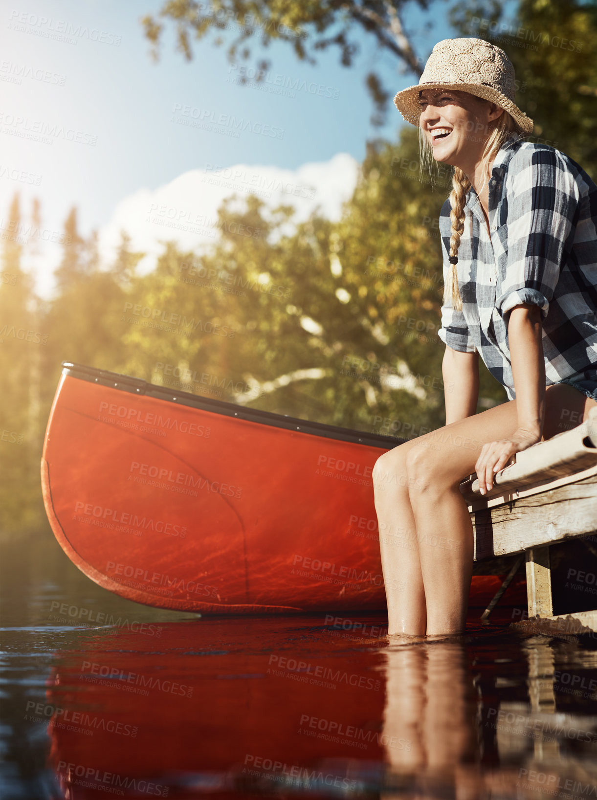 Buy stock photo Shot of an attractive young woman spending a day relaxing by the lake