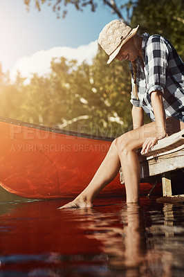 Buy stock photo Shot of an attractive young woman spending a day relaxing by the lake