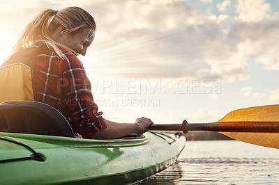 Buy stock photo Shot of an attractive young woman out for canoe ride on the lake