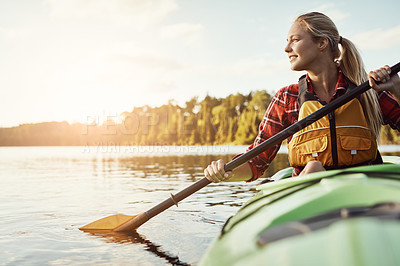 Buy stock photo Shot of an attractive young woman out for canoe ride on the lake