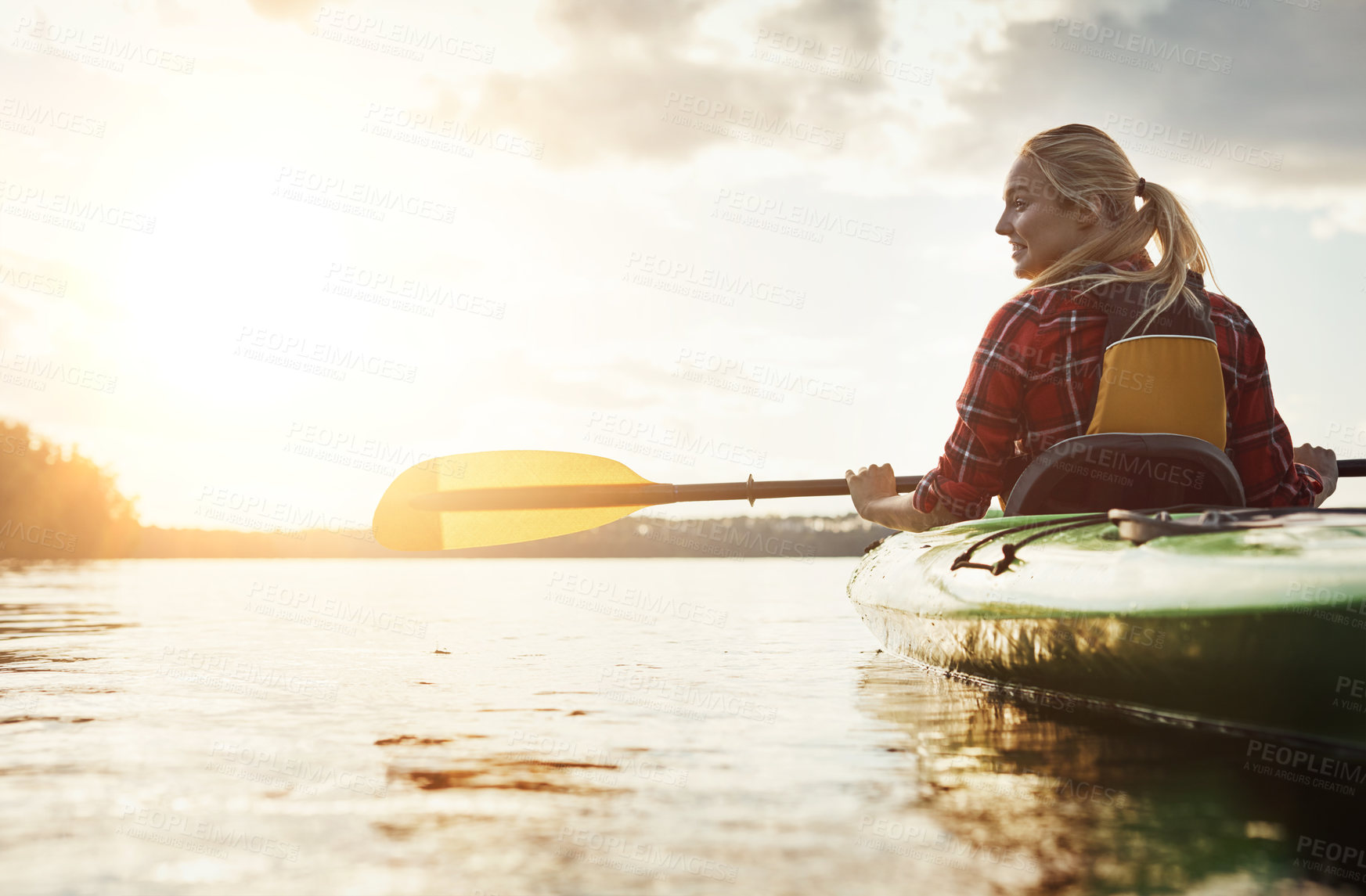 Buy stock photo Shot of a young woman kayaking on a lake