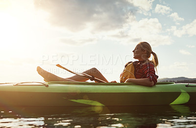 Buy stock photo Shot of a young woman kayaking on a lake