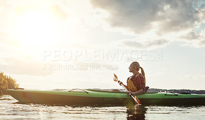 Buy stock photo Shot of a young woman kayaking on a lake