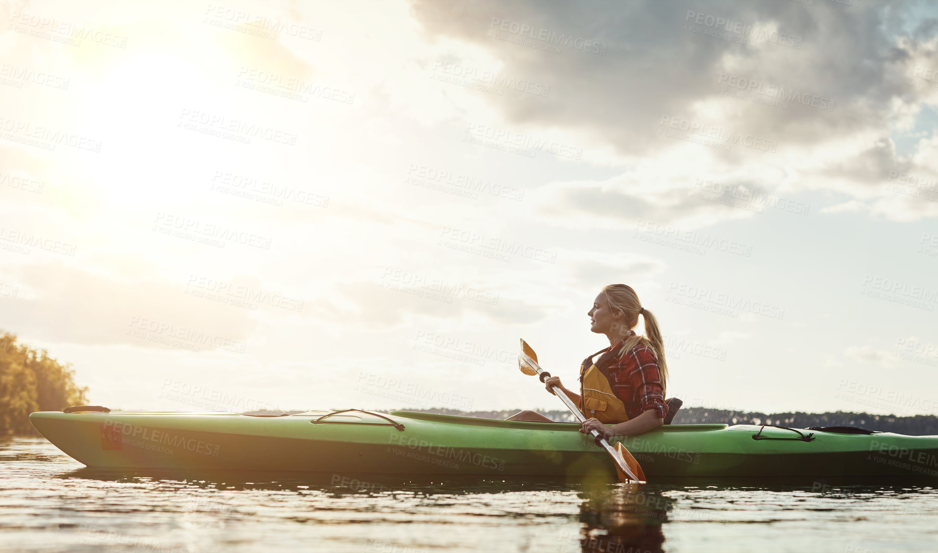 Buy stock photo Shot of a young woman kayaking on a lake