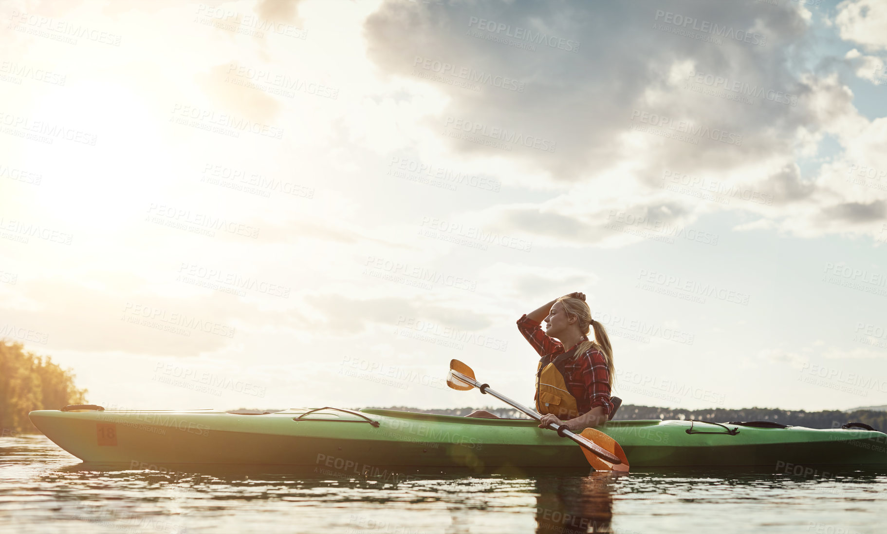 Buy stock photo Shot of a young woman kayaking on a lake