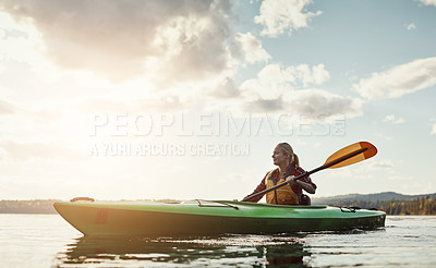 Buy stock photo Shot of a young woman kayaking on a lake