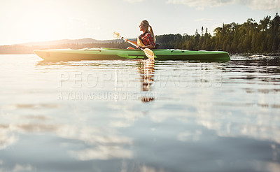 Buy stock photo Shot of an attractive young woman out for canoe ride on the lake