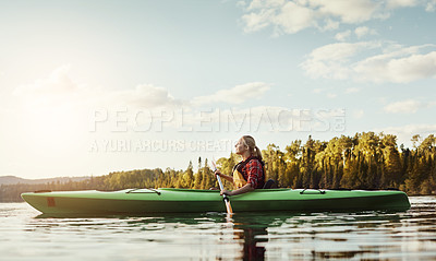 Buy stock photo Shot of an attractive young woman out for canoe ride on the lake