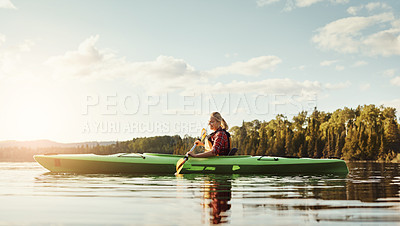 Buy stock photo Shot of an attractive young woman out for canoe ride on the lake